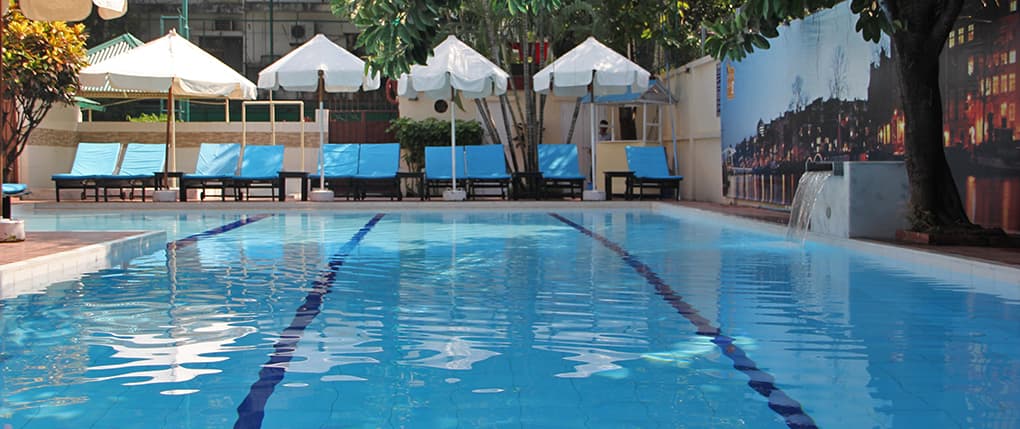 The Dutch Club swimming pool framed by sun loungers and parasols